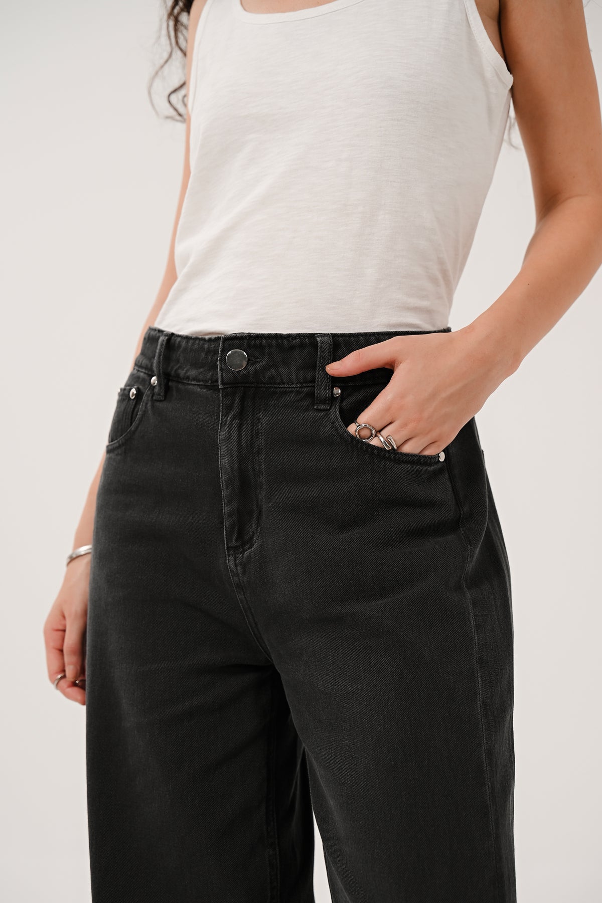 Close-up of the waistband on the black cotton jeans