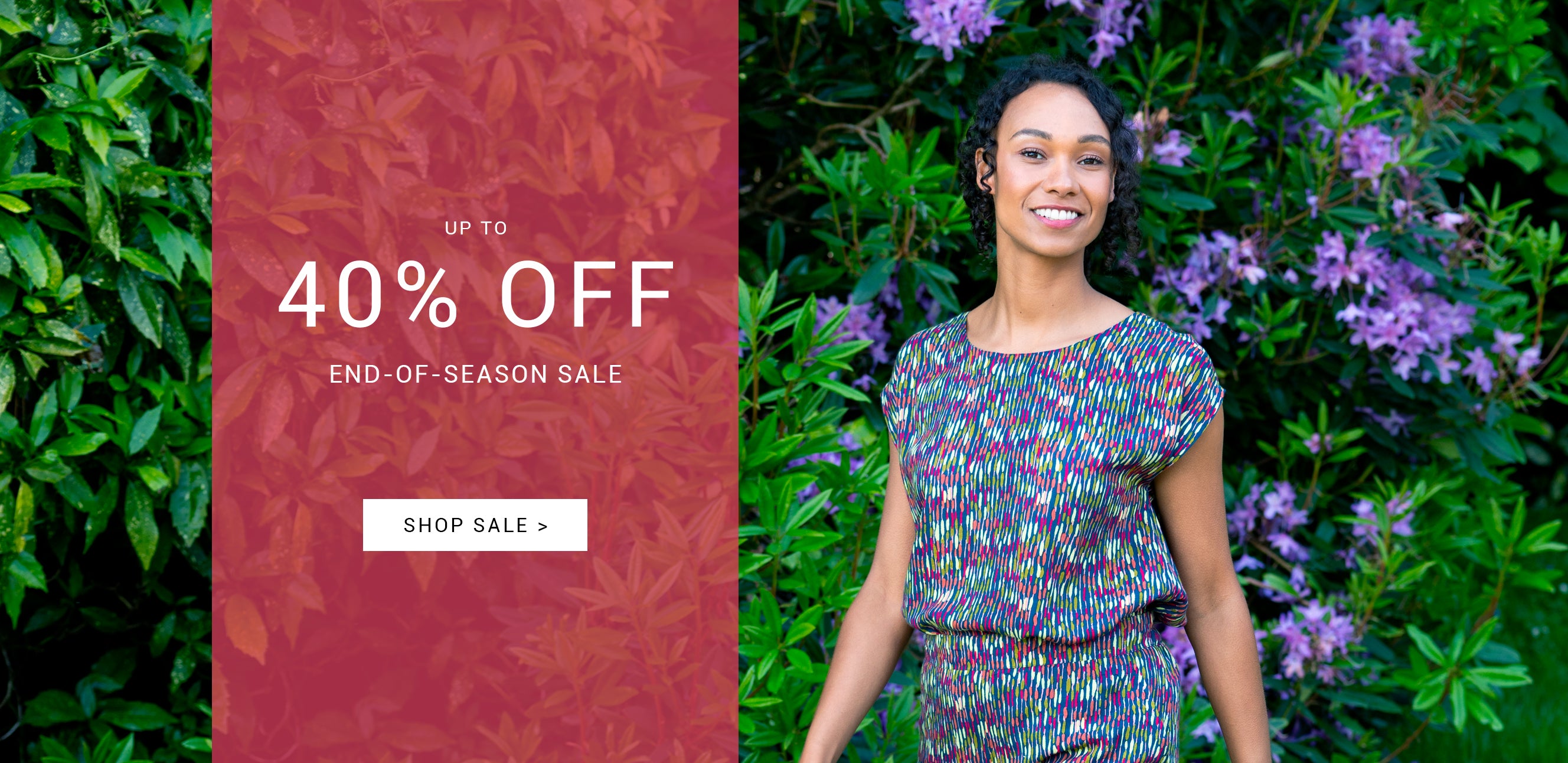Woman in a colourful co-ord standing next to a promotional banner for an end-of-season sale.